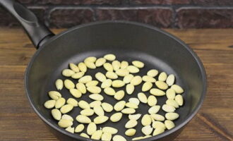 Heat a dry frying pan. Add peeled almonds and dry the kernels.