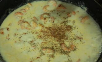 Then pour milk into the shrimp and add a pinch of dry dill, black pepper and nutmeg. Mix these ingredients. Place a piece of butter and chopped melted cheese into the boiling sauce. Stir the sauce again to melt the cheese.