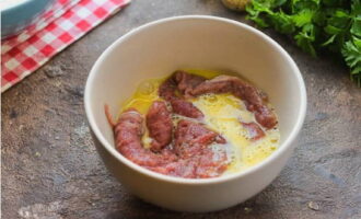 Beat the egg in a bowl and dip the slices of meat.