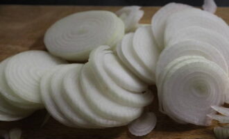 Corte as cebolas em círculos finos. Também colocamos dentro. Regue a massa com azeite e embrulhe em papel alumínio.