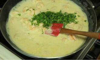 Then add grated hard cheese, finely chopped parsley and chopped garlic to the sauce. Cover the pan with a lid and simmer the sauce over low heat for 5-6 minutes.