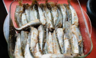 Place the prepared smelt in a baking dish and cover with spices and salt. Mix with your hands and spread the fish in an even layer. Drizzle with olive oil and lemon juice.