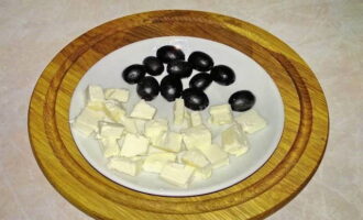 Misurare il numero richiesto di olive snocciolate. Tagliare il formaggio a cubetti ordinati.