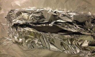 Wrap the fish in foil, leaving a small hole at the top. Cook for 25 minutes at 180 degrees. Then cook for another 5 minutes, reducing the temperature to 160 degrees.