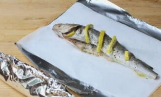 Place parchment on a sheet of baking foil and place the carcass on top. Pack the fish.