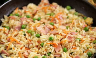 Now put the rice in the pan, add soy sauce, salt and pepper - mix and heat the ingredients for at least three minutes.