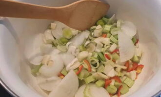 Cut the onions into half rings, cut the leeks into rings, remove the seeds from the hot pepper and chop into rings, chop the white part of the fennel and celery randomly, cut the peeled garlic cloves in half. Place in a deep dish for frying.