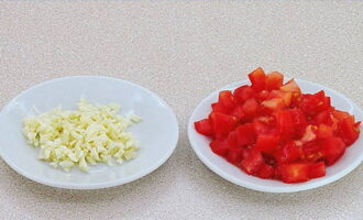 Tagliare l'aglio e i pomodori a cubetti.