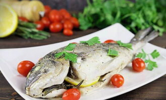 La dorade cuite en papillote au four est prête. Servir avec des légumes et des herbes !