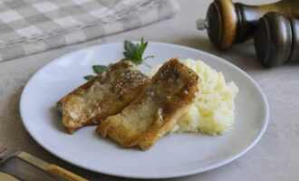 Fried pike, ready in flour in a frying pan. Serve and enjoy!