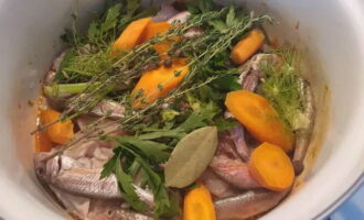 Place small fish, heads and spines on top of the vegetables. Coarsely chop the carrots and add to the pan. Add bay leaves, peppercorns, thyme, and fennel greens there. Season generously with salt.