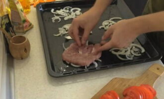 Place the prepared pieces of pork on top of the onion.