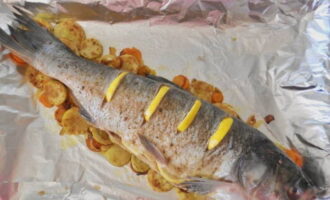 Place pickled silver carp on top and place lemon slices into the cuts.