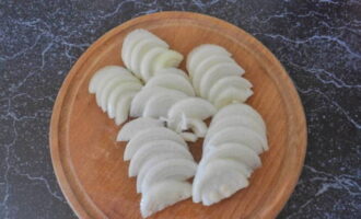 Without wasting time, peel the onion and cut it into half rings.