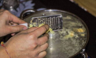 Wasser in einen Topf gießen und zum Kochen bringen. Ingwerwurzel in kochendes Wasser reiben.