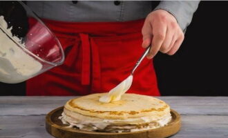 Đặt chiếc bánh pancake đầu tiên lên đĩa phẳng, phết một lớp kem và phủ chiếc bánh pancake thứ hai lên. Vì vậy, chúng tôi thu thập bánh.