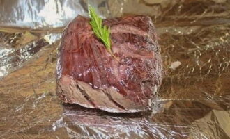 Une fois le temps de marinade écoulé, essuyez à nouveau le filet avec des serviettes et faites-le frire à feu vif dans l'huile chaude jusqu'à ce qu'il soit doré de tous les côtés. Placez le filet frit sur du papier d'aluminium, saupoudrez de sel, ajoutez des brins de romarin pour plus de saveur et enveloppez bien le papier d'aluminium.