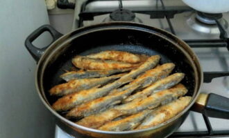 Heat the frying pan well, pour in vegetable oil. Place the fish in portions so that they do not come into close contact with each other. Fry for a couple of minutes over moderate heat on each side. The herring should be well browned and completely baked inside.