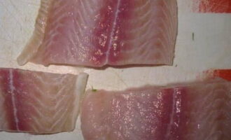 Pré-descongele o filé de pangasius, lave e corte em porções.