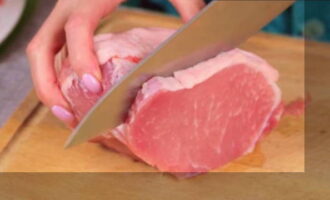 How to quickly and tasty prepare a pork dish for the main course? Cut the frozen piece of pork into slices. The approximate thickness of the slices is 1 cm.