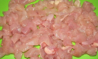 Preparemos el filete de pollo. Se debe lavar con agua, secar y cortar en cubos pequeños. Es conveniente hacerlo con carne ligeramente congelada.