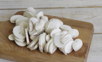 Pasta with mushrooms is prepared quickly and tasty. We wash and clean the champignons well, then cut them into thin slices.