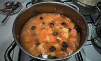 Placer les pommes de terre hachées dans le bouillon de poulet et cuire jusqu'à ce qu'elles soient tendres. Ajoutez-y ensuite des légumes cuits, des tranches de saucisses, du poulet et des olives.