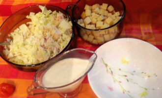 Zout de salade en meng het. Verdeel de salade over borden en garneer met croutons.