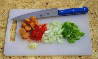 Cut the sausages into slices. Chop onion, tomato, bell pepper and garlic.