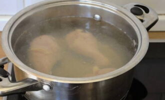 Pour water into the pan and place the washed chicken. Place it on the burner. Wait for it to boil, remove the foam with a slotted spoon. Reduce heat and continue cooking until the meat is cooked.