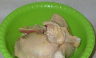 We wash the chicken under water and chop it into portions. Also add salt and mix.