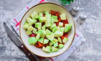 Keluarkan kulit dari zucchini yang terlalu besar dengan pembantu rumah, kikis biji dan bahan berserabut. Sayuran muda dengan kulit lembut tidak perlu dikupas. Potong zucchini menjadi empat segi.