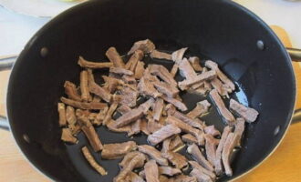 Heat the oil in a frying pan and fry the meat until the color changes, add a little water and cover with a lid.