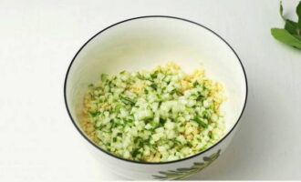 Tuangkan bulgur yang telah direbus ke dalam mangkuk salad yang dalam dan tambahkan hirisan timun.