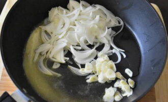 Heat a frying pan with vegetable and butter. Fry onions and garlic here. It is necessary that the vegetables become soft and release a bright aroma.