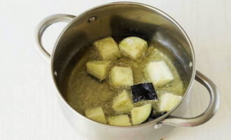 Pflanzenöl zum Frittieren in einer beliebigen Schüssel erhitzen und die Auberginen nacheinander bei starker Hitze knusprig braten. Überschüssiges Öl können Sie mit einer Papierserviette entfernen.