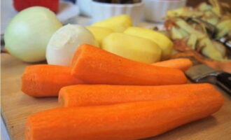 At the same time, we arm ourselves with a vegetable peeler and remove the peels from potatoes and carrots. Peel the onion.