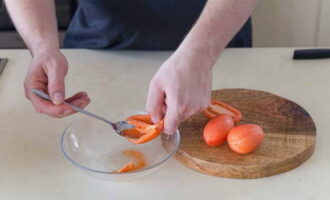 Cut the peeled tomatoes into halves. We extract juice and seeds from them.