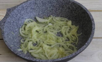 Drop onion half rings into the aromatic oil. Fry until soft.