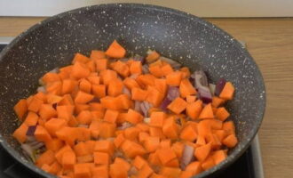 Place the frying pan on the stove and heat it up, first pour in vegetable oil. Transfer carrots and onions. Sauté, turning the slices periodically, until the carrots soften.