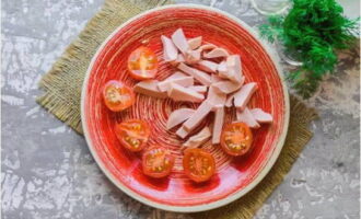 Cut the washed tomatoes in half and chop the sausage randomly. At the same time, heat the vegetable oil in a frying pan.