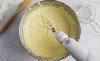 Pour the eggs into the creamy mixture, then add the cream and beat well. Add the sifted flour and knead the glossy mixture.