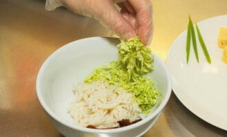 Snijd het zachtgroene deel van de Chinese koolbladeren fijn en doe dit bij de overige ingrediënten in de kom.