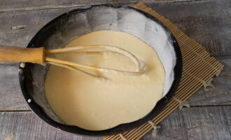 Pour half of the dough into a baking dish, previously greased with butter.