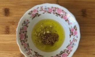 Dans une assiette creuse, mélanger l'huile d'olive, le jus de citron, la moutarde de Dijon, la gousse d'ail hachée, une pincée de sel et le poivre noir moulu. Bien mélanger.