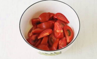 Die Tomaten waschen, trocknen und in gleich große Scheiben wie die Aubergine schneiden. Legen Sie sie in eine tiefe Salatschüssel.