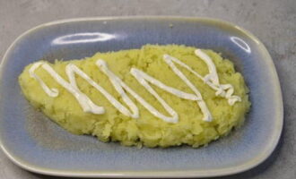 Formem l'amanida. Col·loqueu la primera capa de patates prèviament bullides, refredes i ratllades en un plat pla. Col·loqueu la capa de verdures amb força i aboqueu-hi maionesa.