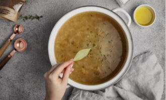 Despeje a mistura de cebola em uma panela maior, acrescente o caldo, o louro e o tomilho. Leve os ingredientes para ferver e cozinhe em fogo baixo por cerca de 60 minutos.