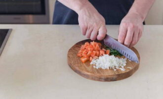 Cut the remaining parts of the tomatoes into small cubes. We also chop the onions and basil leaves.