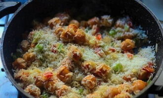 Pour dry rice into the contents. Fry everything together for about two to three minutes.